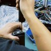 Техник проводит стендовые испытания цифровой приборной панели для конкретной модели автомобиля в ходе гарантийной проверки